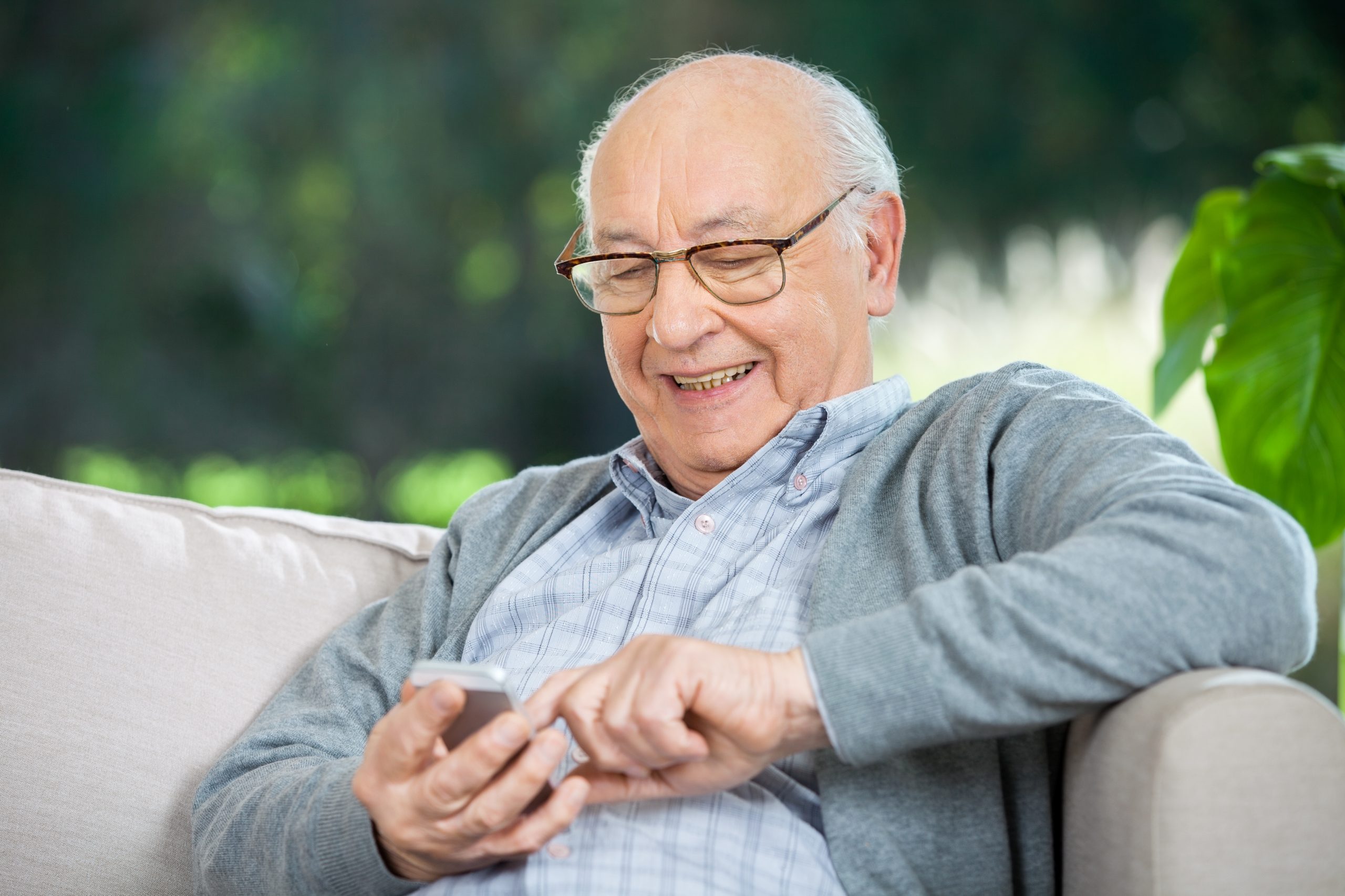 Senior man smiling at smartphone